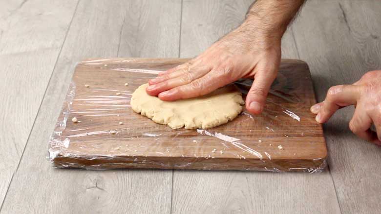 Flattening the dough with fingers to form a thick disk – Kaju Katli Recipe