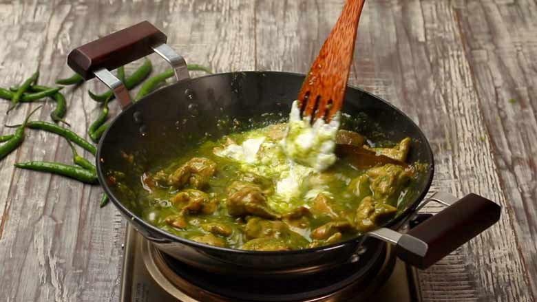 Stirring yogurt into hariyali chicken