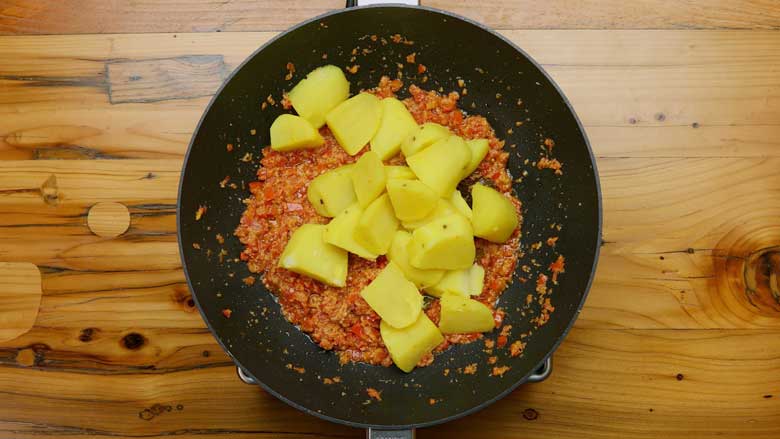 Cooked potatoes added to the masala in aloo ka korma recipe
