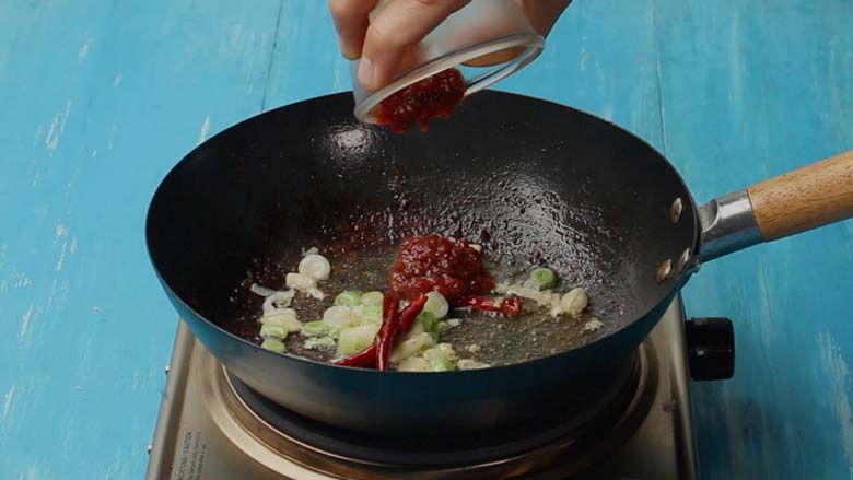 Add chilli bean paste to the wok and stir fry - Chilli Chicken Szechuan Style Recipe