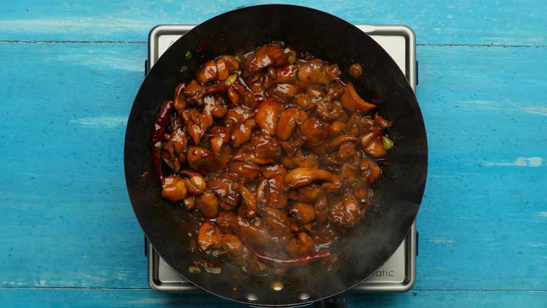 Add chicken back to the wok and continue to stir fry - Szechuan Chilli Chicken Recipe