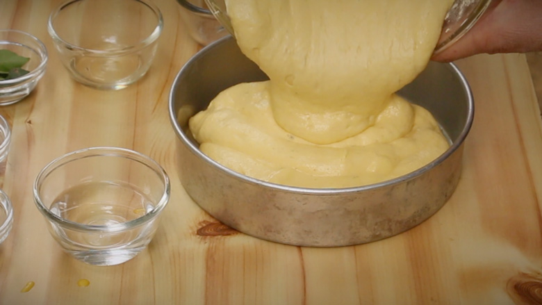 Pour dhokla batter into a prepared (oiled) cake tin and tap on counter top to smooth out before steaming - Khaman Dhokla Recipe