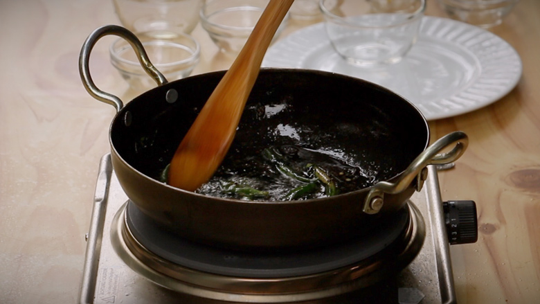 Make tempering (tadka) with oil, mustard seeds, curry leaves, green chillies, salt, and sugar - Khaman Dhokla Recipe