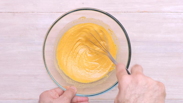 Add hot oil and water to the dry batter ingredients and mix to making a flowing batter - Vada Pav recipe