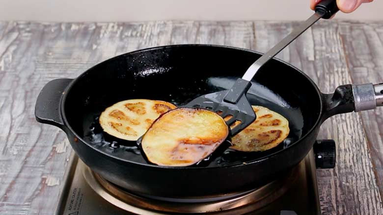 Fry slices of eggplant (brinjal) till golden brown then drain on kitchen paper - Badal Jaam Recipe