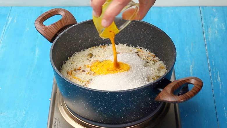 Turn heat to low then add sugar and saffron soaked in hot milk - Zarda Pulao Sweet Rice Recipe