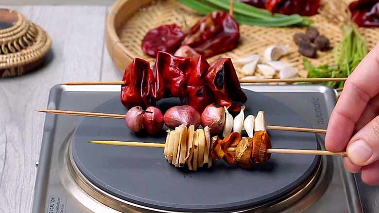 Roast the dried red chillies, shallots, garlic, ginger, and fresh turmeric over a flame or over a grill - Khao Soi Recipe - Chiang Mai Curried Noodles