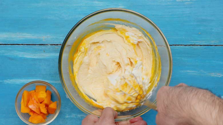 Use a balloon whisk or a fork to stir in the mango puree - Mango Shrikhand Recipe