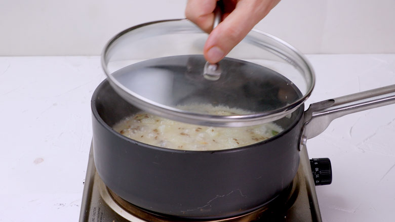 Pour in water, add rock salt (sendha namak), stir, then cover and cook till the water is absorbed, 4 to 5 minutes - Vrat ke Chawal - Samak Rice recipe for fast
