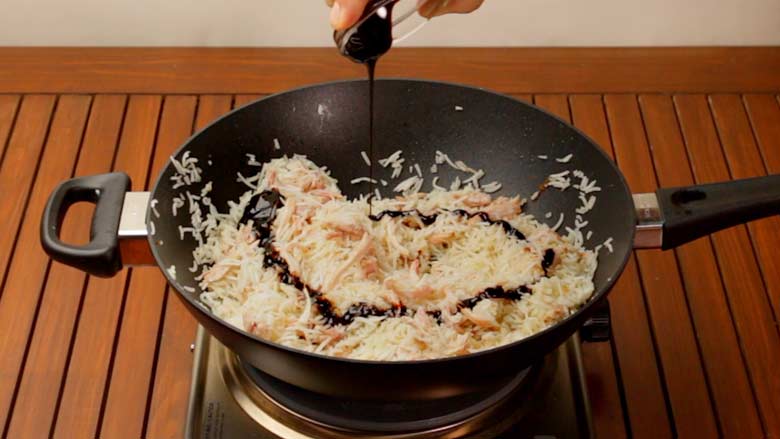 Pour in kecap manis (sweet soy sauce) and toss well - Indonesian Style Fried Rice Nasi Goreng Recipe