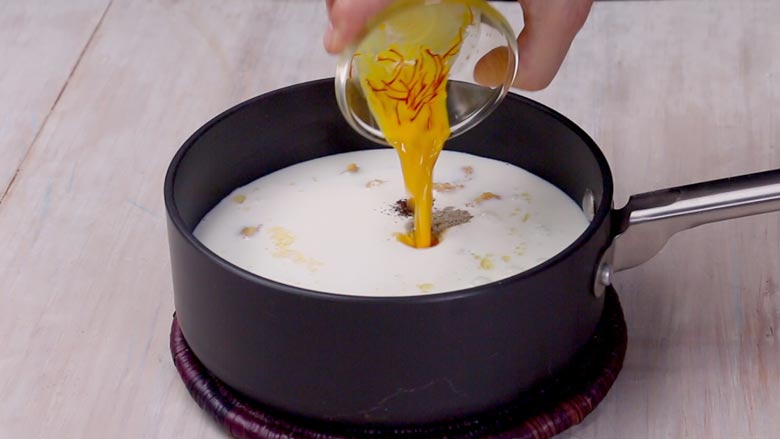 Pour milk and cream into the dal, followed by the saffron soaked in milk - Dal Sultani Recipe