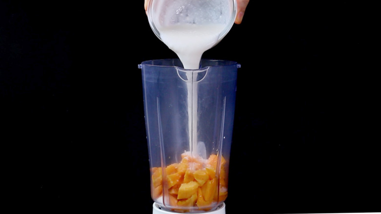 Place diced mango in a blender or food processor. Add powdered sugar, yogurt, ice cubes, and milk - Mango Lassi Recipe 