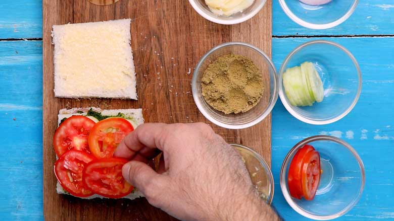 Top with the chutney covered slice of bread and place tomato slices on it - Bombay Sandwich Recipe