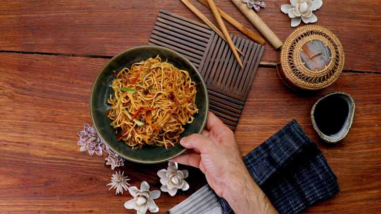Transfer to a serving bowl and garnish with sliced spring onions - Veg Hakka Noodles Recipe