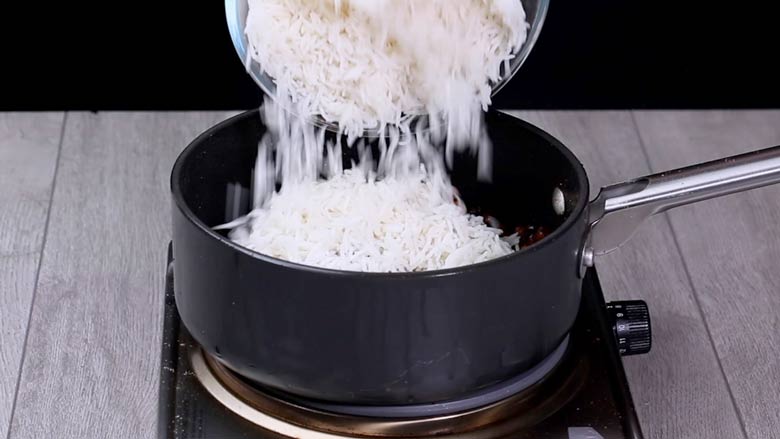 Tip in cooked rice and mix gently in a folding motion - Kala Chana Pulao Recipe