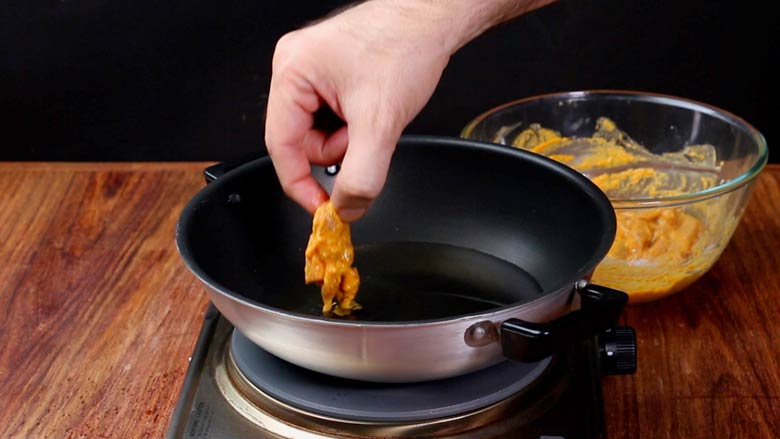 Heat oil then fry marinated chicken pieces without crowding the kadhai - Chicken 65 Recipe