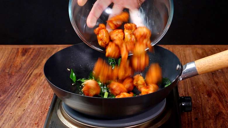 Prepare tempering of curry leaves, garlic, and green chillies, then add fried chicken. Sauté till well coated adding optional yogurt if using - Chicken 65 Recipe