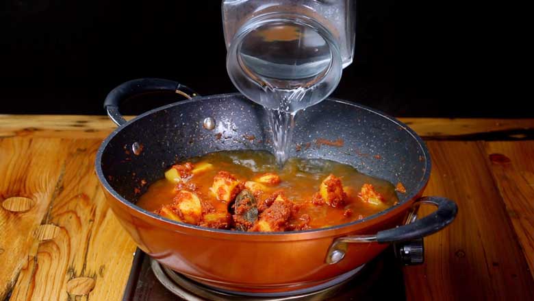 Pour in water, bring to a boil, then cook till potatoes are half done - Aloo Paneer recipe video