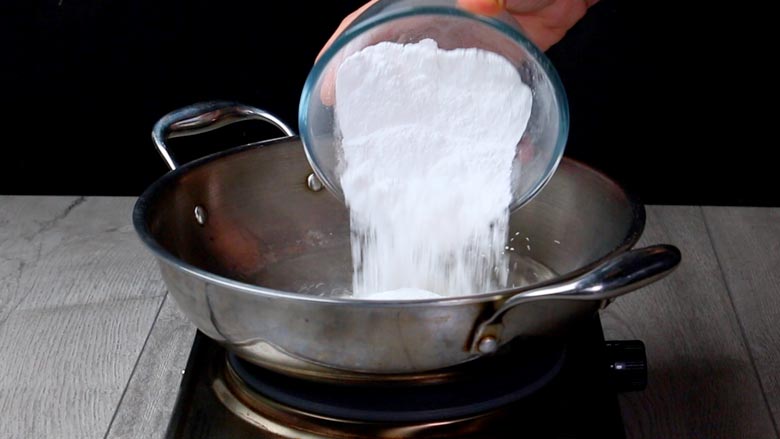 tip in powdered sugar in boiling water and stir till dissolved - Besan Prasad Recipe