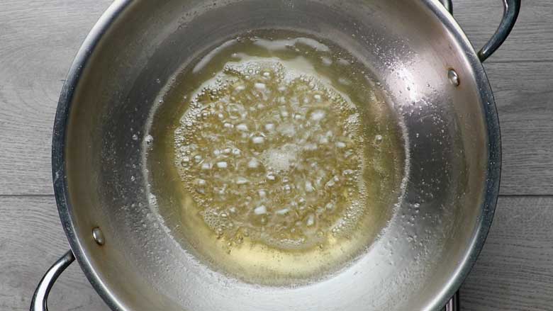 Make chashni (sugar syrup) boil and continue to cook till the chashni or syrup reaches half thread consistency - Besan Prasad Recipe