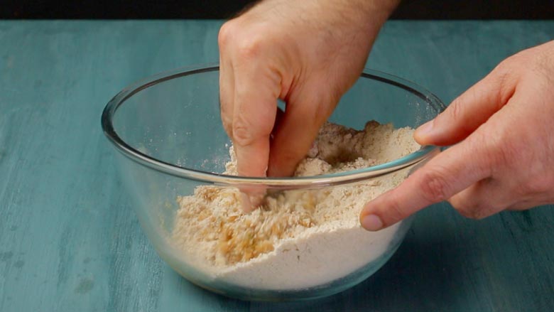 Tip whole wheat flour (atta) into a large bowl and add desiccated coconut, fennel seeds (saunf), and cardamom powder. Add half the jaggery syrup - Thekua Recipe