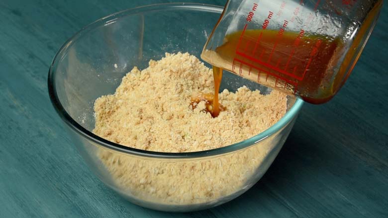  Rub flour with your hands till it resembles bread crumbs, then pour in small additions of jaggery syrup and knead - Thekua Recipe