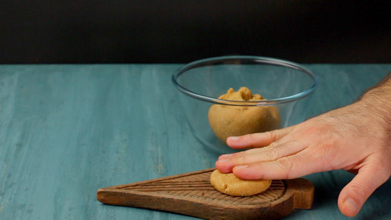 Flatten to a small disk and then press down hard onto the thekua mould or saancha to spread it to a 2 1/2 inch round thekua shape - Thekua Recipe
