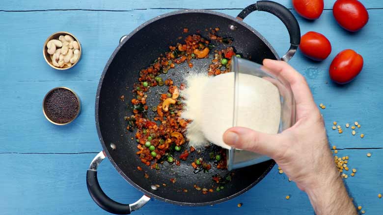 Add semolina (rava - sooji) that has been dry roasted already and stir to mix well - Tomato Bath Upma Recipe