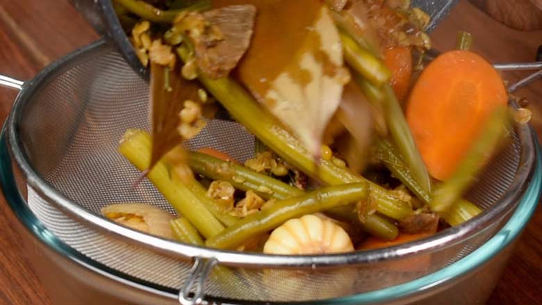 Pour reduced veg stock through a strainer - Vegetable Stock Recipe by Yummefy