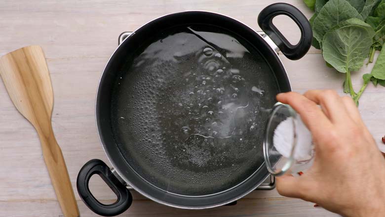Bring water to a boil and add oil, salt, asafoetida, and baking soda - Kashmiri Haak Recipe