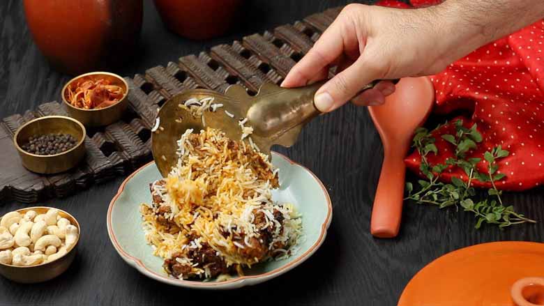 Hyderabadi Dum Biryani - an ambrosial combination of fragrant rice and succulent meat, topped with the sublime flavours of fried onion (birista), saffron, ghee, and mint - Hyderabadi Dum Biryani recipe