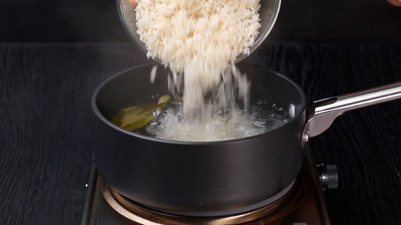 Cook soaked rice with whole spices till half done, about 5 minutes - Hyderabadi Dum Biryani Recipe