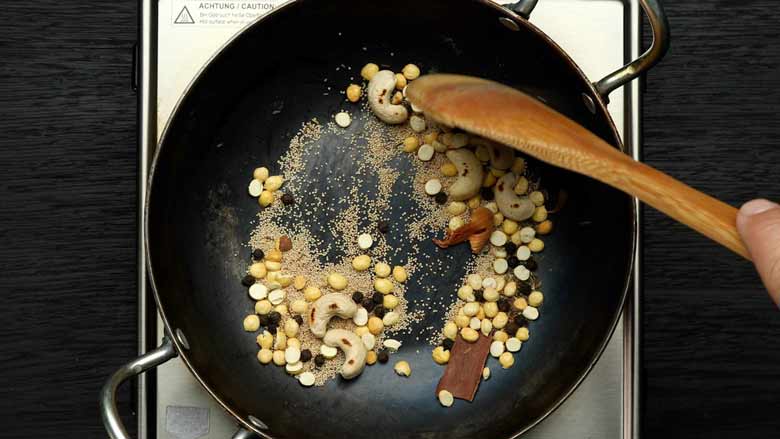 Dry roast spices - cashew nuts, cinnamon, black peppercorns, caraway seeds (shahi jeera), mace (javitri), poppy seeds (khus khus), and roasted Bengal gram (roasted chana dal) - till aromatic - Hyderabadi Dum Biryani Recipe