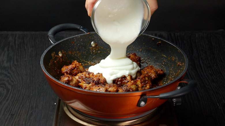 After browning mutton with red chilli powder, turmeric, and fried onions (birista), reduce heat and add yogurt, green chillies, coriander leaves and mint leaves - Hyderabadi Dum Biryani Recipe