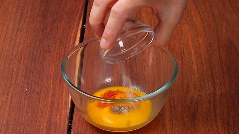 Place egg yolks in a bowl and add black pepper powder, red chilli powder, turmeric powder, and salt. Mix well - Masala Omelette Recipe