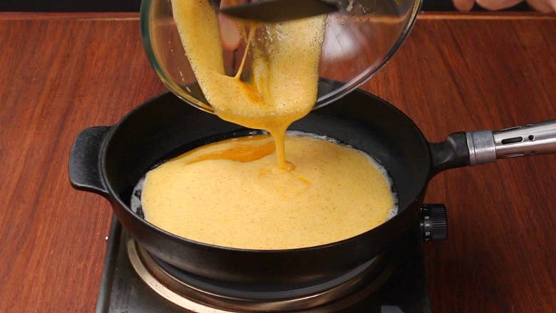 Heat oil and butter in a heavy frying pan and pour in the egg mixture - Masala Omelette Recipe