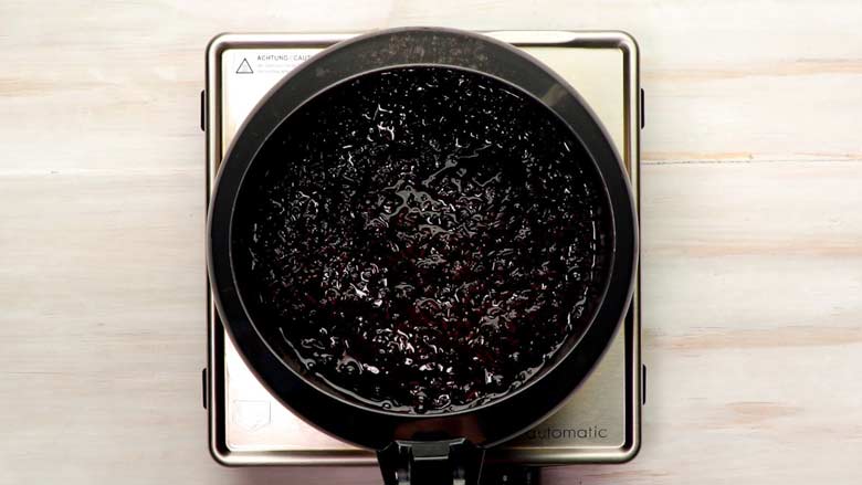 Top view of cooked black rice in a pressure cooker on a square steel electric stove after the lid has been removed - in preparation for kavanarisi