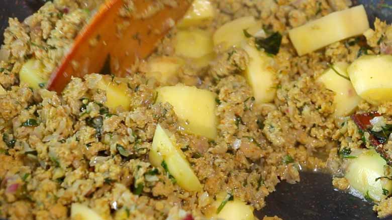 Minced meat or keema being sautéed with potatoes - stirred with a wooden spatula - Keema Curry Recipe Konkani Style