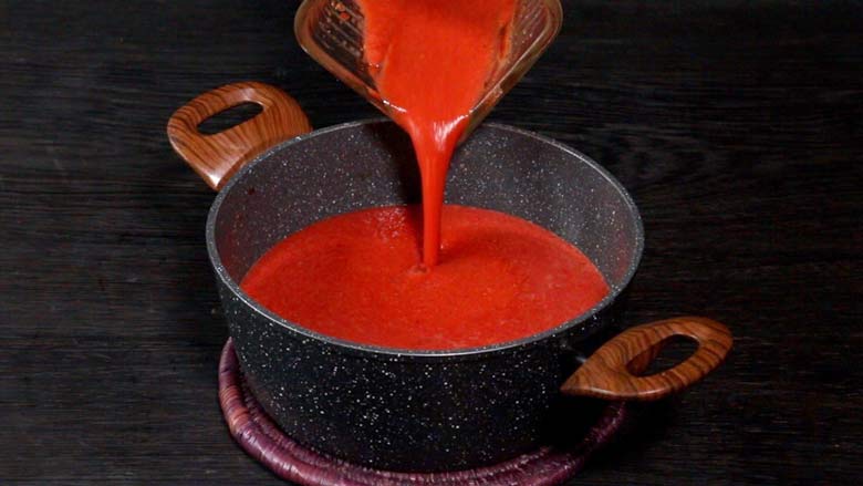 Blended veg borsht soup is being poured back from the blender into the black and white speckled non stick saucepan to be reheated - Borscht Soup Recipe