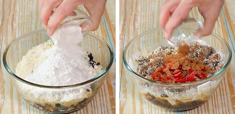 Dry ingredients including spices being added to soaked dry fruits in a glass bowl on a blonde wood table while preparing a Christmas Pudding recipe