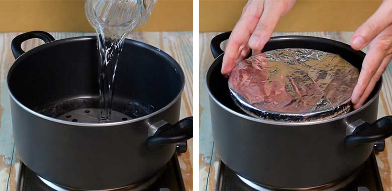 A trivet is placed at the bottom of a deep black pan and water added to act as a bain-marie, then the foiled covered pudding bowl is placed in it - to cook the Christmas pudding - Easy Christmas Pudding recipe