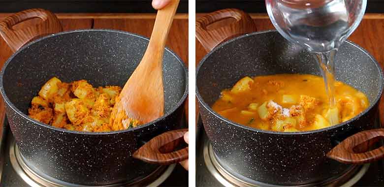 A wooden spatula stirs potatoes to coat them with the masala in a black and white speckled non stick pan with large wooden handles on the left while 2 cups hot water is being added to the potatoes in the same pan on the right side - Konkani Potato Curry Recipe