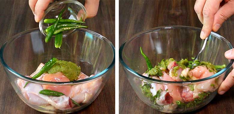 Green chillies are being added to the marinade and chicken in a glass bowl lying on a wooden countertop on the left side with hands are seen using a spoon to mix and coat the chicken well with the marinade on the right - Village Style Chicken Biryani Recipe